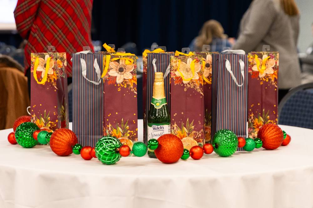 Goodie bags on a table with red and green ornaments surrounding them